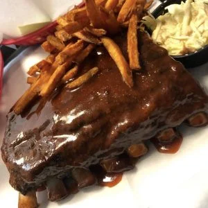 Barbecue-sauced ribs served with sweet potato fries and coleslaw.