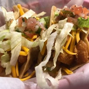 Battered shrimp tacos with lettuce and pico de gallo at Rooster's