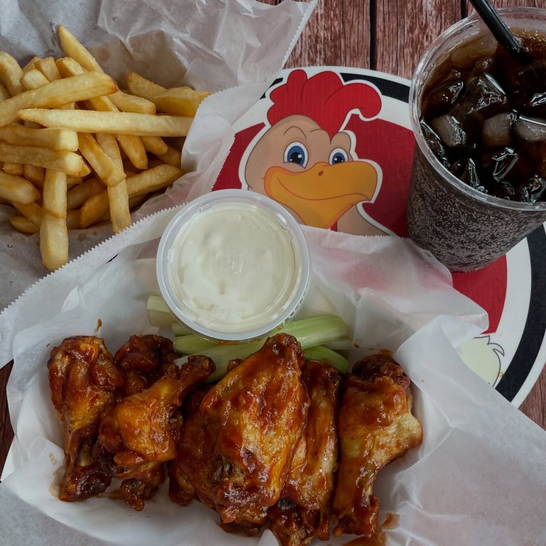 Rooster's wings, fries and bottled soda on a Rooster's placemat